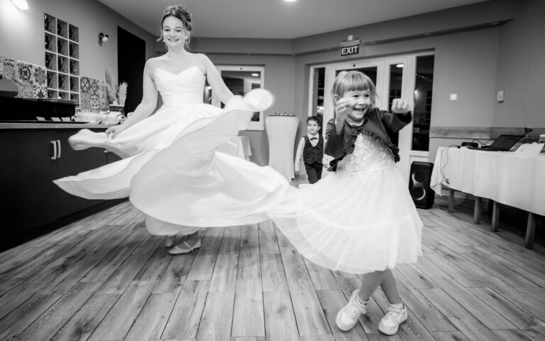 A menyasszony forgatja a ruháját, amit egy kislány utánoz. Esküvői fotós debrecen